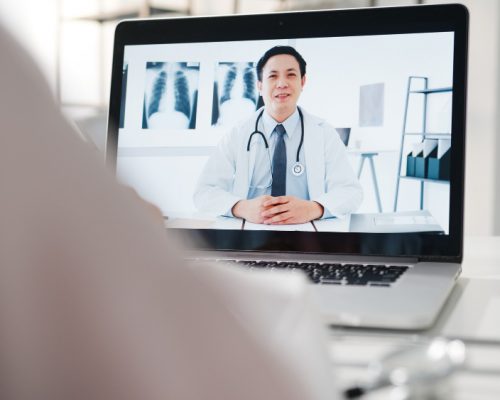 young-asia-male-doctor-white-medical-uniform-using-laptop-talking-video-conference-call-with-senior-doctor-desk-health-clinic-hospital